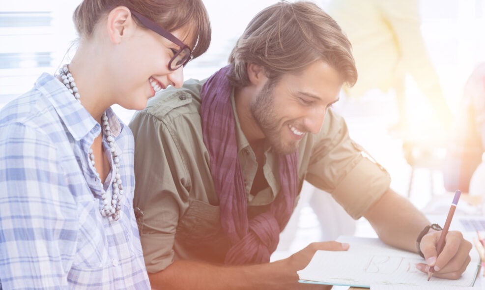 happy-designers-working-document-with-colleagues-working-1200x590